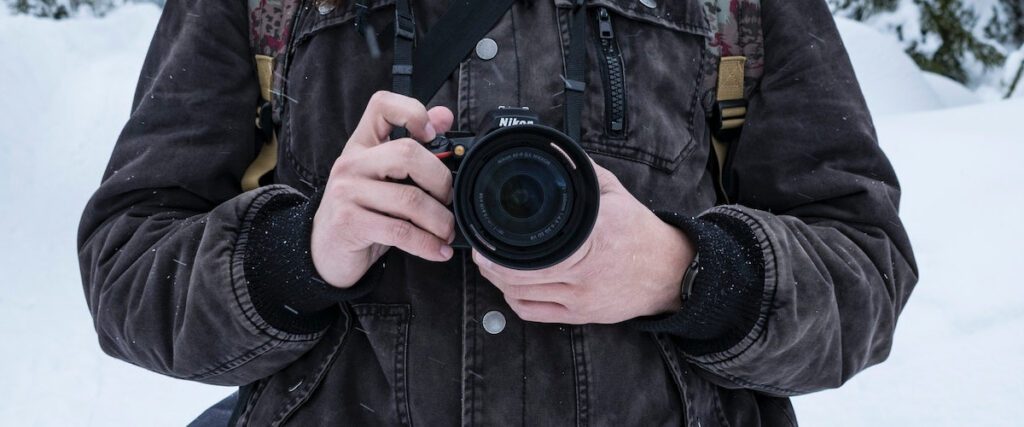 Man holding a camera in winter