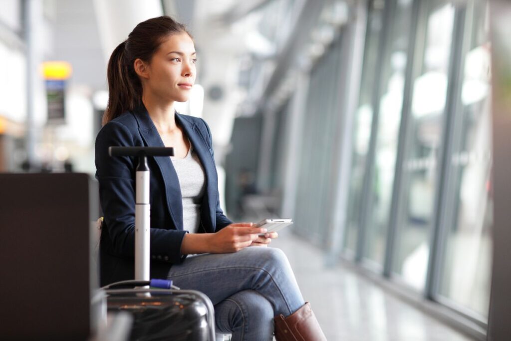 Girl Sitting in Airport with Phone