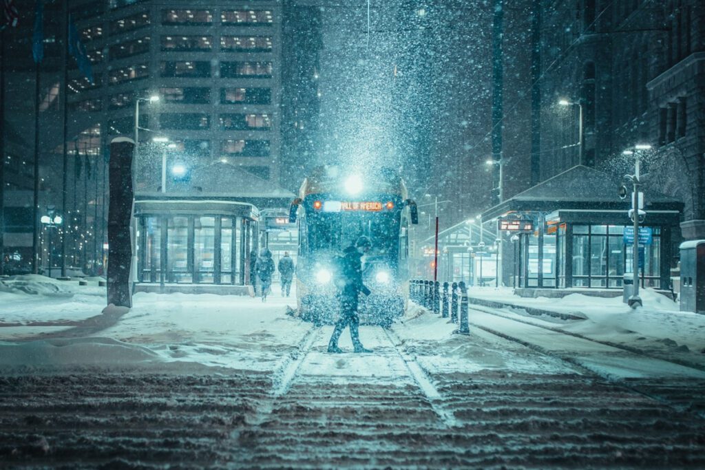 Man Crossing Snowy Street in Front of Tram